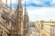 Roof of Milan Cathedral Duomo di Milano with Gothic spires and white marble statues. Top tourist attraction on piazza in Milan, Lombardia, Italy. Wide angle view of old Gothic architecture and art.