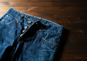 Blue jeans on a wooden background with copy space