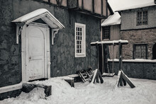 Beautiful Facade With A Door. Abandoned Building And Old Swing Nearby. Winter Snowy Day.