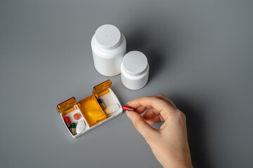 Wall Mural - Pills and capsules in pill organizer. Medical Concept, Illustration of Pharmacy Bag with Pill Container or Pill Box on gray background. 
Disease prevention. 