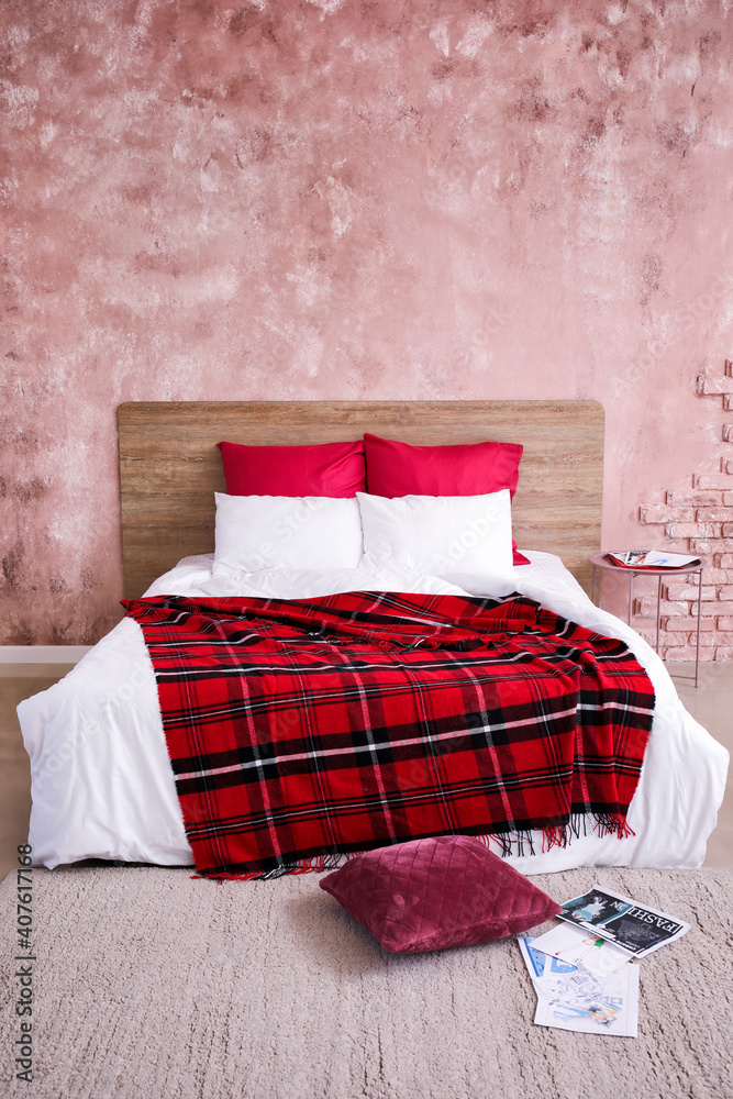 Comfortable bed near color wall