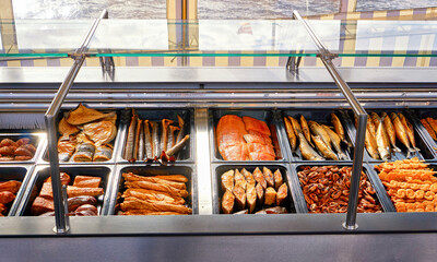 Smoked fish for sale on a boat in the harbor with Baltic Sea water in the background.