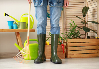 Poster - Woman in gumboots with gardening supplies in barn