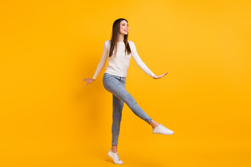 Sticker - Full size photo of optimistic girl dance wear sweater jeans sneakers isolated on yellow color background