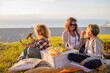 © simona - Happy alternative family mothers enjoy outdoor leisure activity together in picnic on the grass - sunny day of vacation with friends - couple of women and son eat and have fun in sunny day