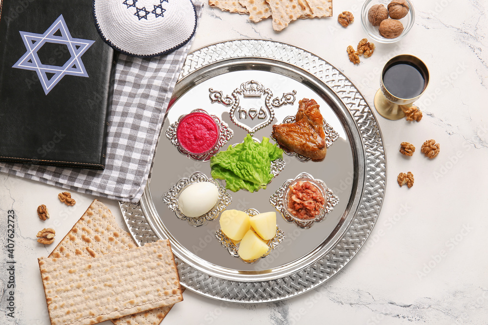Passover Seder plate with traditional food and Torah on white background
