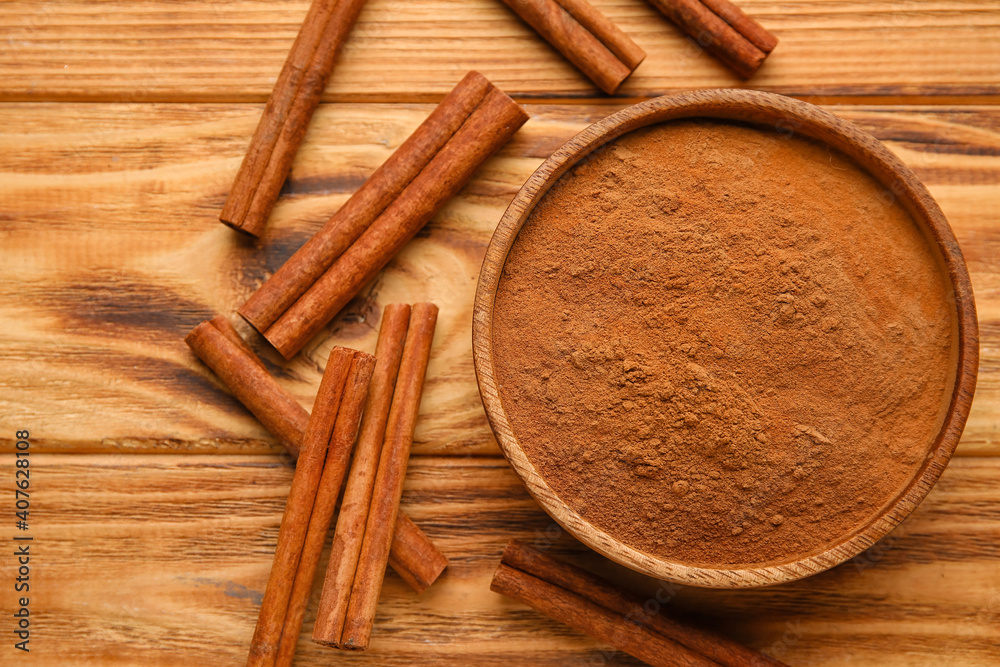 Cinnamon sticks and powder on wooden background