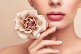 Beautiful model with a rose. Perfect woman face makeup close up. Lipstick. Beautiful nails