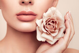 Beautiful model with a rose. Perfect woman face makeup close up. Lipstick. Beautiful nails