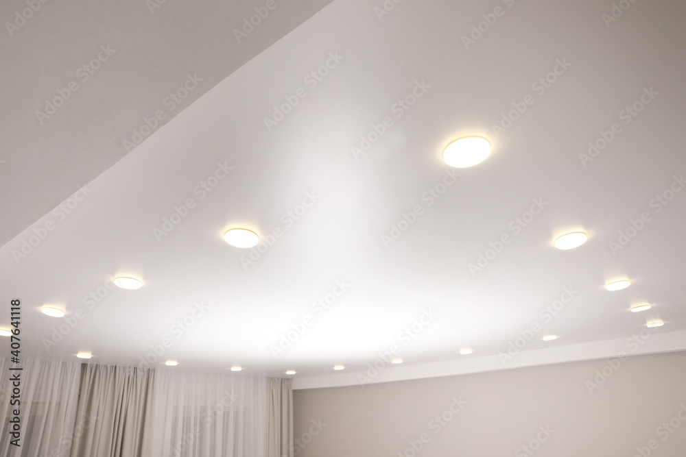 White stretch ceiling with spot lights in room - obrazy, fototapety, plakaty 