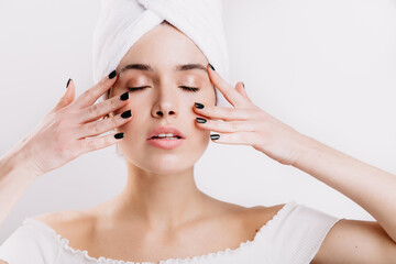 Sticker - Adult woman with healthy skin massages her face to prolong youth. Snapshot of girl after shower on isolated background