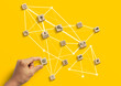 Business strategy to success, business management or start up business concept. Hand is arranging wooden blocks with business icon in low polygon rocket shape network on yellow background.