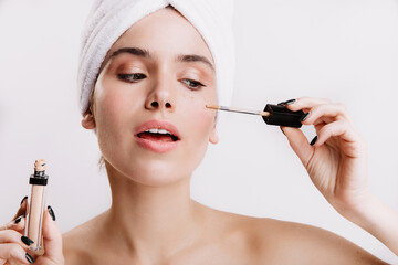 Sticker - Girl after shower put concealer under eyes. Portrait of beautiful woman on white background