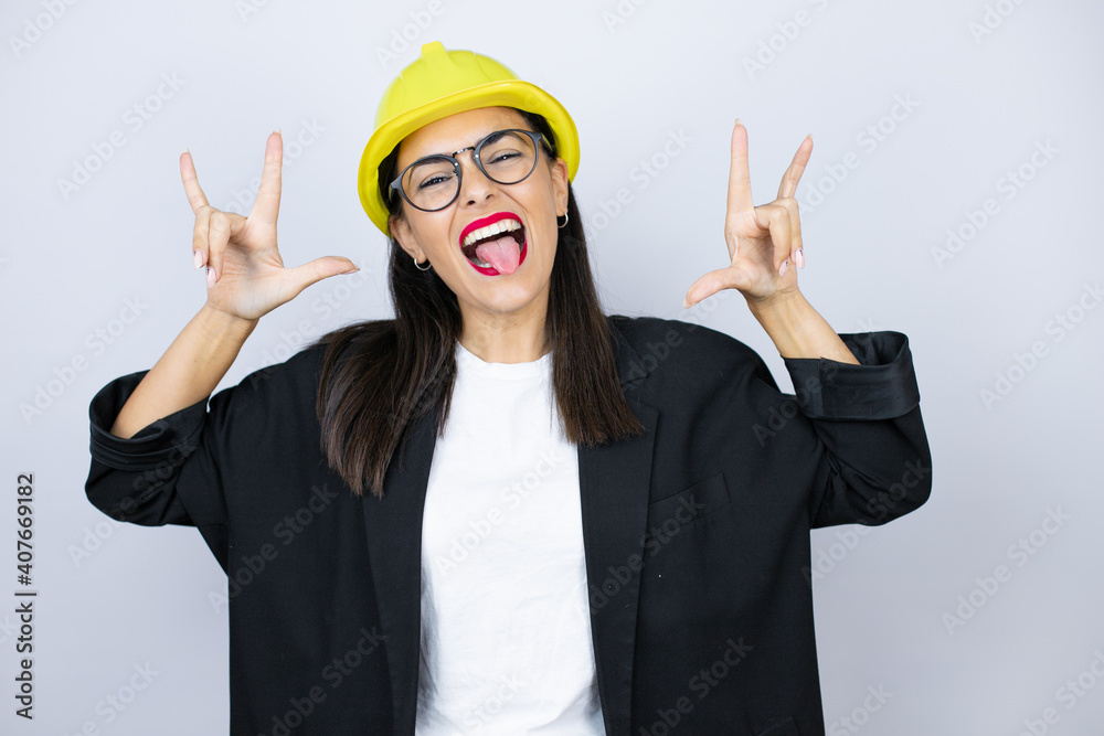 Young architect woman wearing hardhat shouting with crazy expression ...