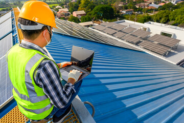 Wall Mural - Engineers use a laptop computer to examine the solar panels on the roof of a house where the solar panels are installed using solar energy.