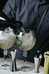 Cocktails with champagne in wine glasses on the bar table in the pub or restaurant with the bartender.