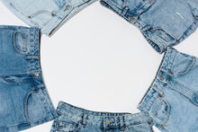 Empty Frame Made From Various Blue Jeans On White Background, Top View