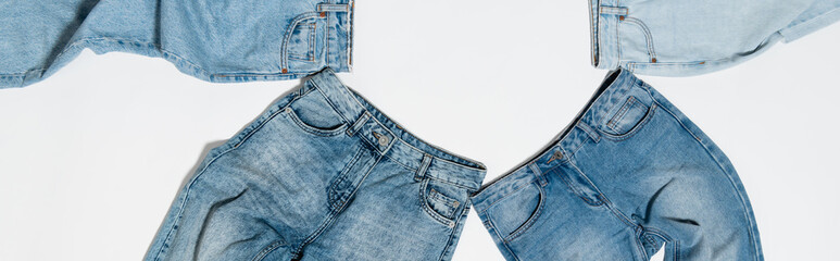 Wall Mural - top view of different blue jeans on white background, banner