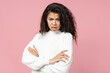 © ViDi Studio - Young indignant displeased african american woman 20s curly hair in white knitted sweater look camera hold hands crossed folded isolated on pastel pink background studio portrait. Lifestyle concept.
