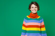 © ViDi Studio - Smiling cheerful beautiful attractive young brunette woman 20s years old wearing basic casual colorful sweater standing and looking camera isolated on bright green color background studio portrait.
