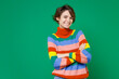 © ViDi Studio - Smiling beautiful young brunette woman 20s years old wearing basic casual colorful sweater standing holding hands crossed looking camera isolated on bright green color background studio portrait.