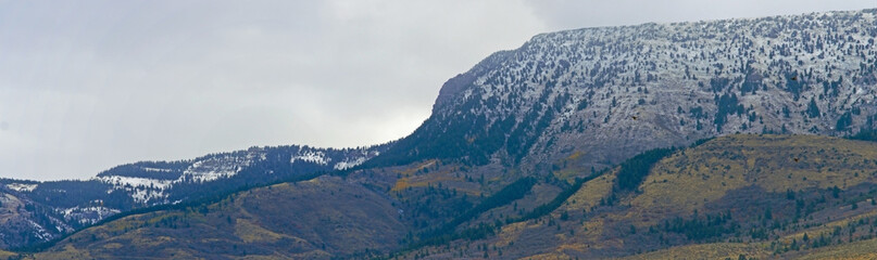 Poster - Panoramic shot of mountains covered with snow in the daytime under the gloomy sky