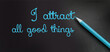 I attract all good things - positive affirmation words - handwriting on a black paper with blue pencil. Law of attraction concept