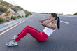 © WavebreakMediaMicro - Fit african american woman in sportswear doing crunches on a coastal road