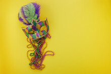 Mardi Gras Or Carnival Mask With Beads On Yellow Background. Venetian Mask.