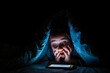 © Aycan - Little girl is surprised to see the phone screen in bed in the dark