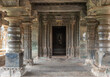 © Klodien - Lakkundi, Karnataka, India - November 6, 2013: Brahma Jinalaya temple. Doorway from Mandapam into sanctum has highly sculpted frame. Sculpted pillars in front. Idol far in back.