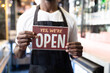 © Wavebreak Media - Portrait of african american male barista holding a were open card
