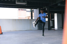 African American Man Doing Tricks With A Football In Empty Urban Building