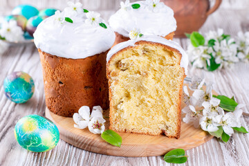 Easter composition with traditional Russian Easter bread kulich, Easter eggs and flowers on table. Happy Easter concept