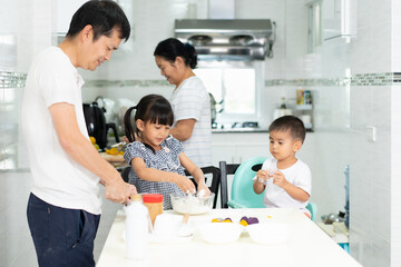 Wall Mural - Multigeneration people in the family are happy to prepare and cooking the dessert in the kitchen with happy moment, concept of practical life learning for child through home based activity.