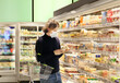 © lado2016 - supermarket shopping, face mask and gloves,man choosing frozen food from a supermarket freezer