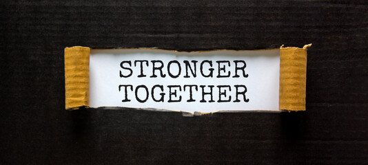 Wall Mural - Stronger together symbol. Words Stronger together appearing behind torn black paper. Business, motivational and Stronger together concept. Copy space.