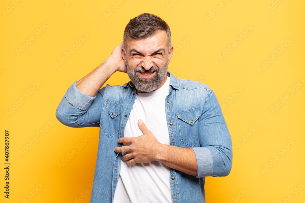adult handsome man feeling stressed, frustrated and tired, rubbing painful neck, with a worried, troubled look - obrazy, fototapety, plakaty 