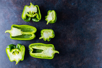 Ugly bell pepper on dark background. Sliced bell pepper halves on the table. Concept - reduction of food organic waste. Non GMO vegetables. Copy space. Top view