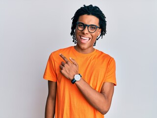 Wall Mural - Young african american man wearing casual clothes and glasses cheerful with a smile of face pointing with hand and finger up to the side with happy and natural expression on face