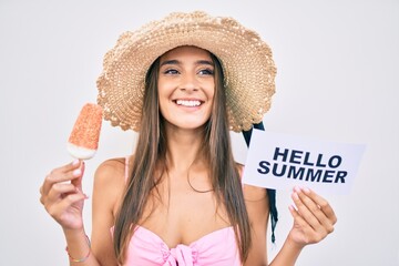 Wall Mural - Young woman on vacation holding hello summer banner and eating ice cream at street of city