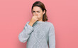 © Krakenimages.com - Young caucasian girl wearing casual clothes smelling something stinky and disgusting, intolerable smell, holding breath with fingers on nose. bad smell