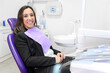 © herraez - Portrait of smiling young woman lying in dental chair and looking at camera, copy space. High quality photo