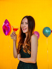 Wall Mural - Portrait of Asian beautiful young woman in party standing on yellow background copyspace 