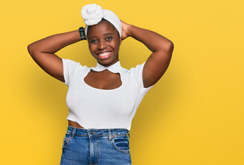 Wall Mural - Young african woman with turban wearing hair turban over isolated background relaxing and stretching, arms and hands behind head and neck smiling happy