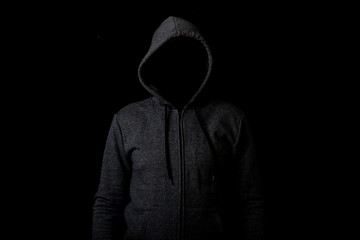 Man without a face in a hood on a dark background