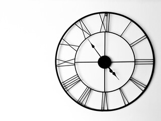 Poster - Closeup shot of a black vintage clock hanging on a white wall