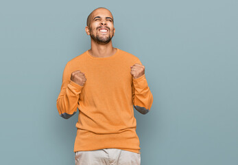 Sticker - Hispanic adult man wearing casual winter sweater excited for success with arms raised and eyes closed celebrating victory smiling. winner concept.