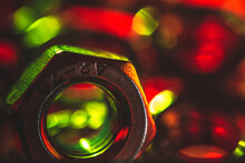 Selective Focus Shot Of A Metal Screw Nut With Red And Green Lights Falling On It