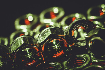 Sticker - Closeup shot of metal screw nuts placed on the top of each other in a dark atmosphere